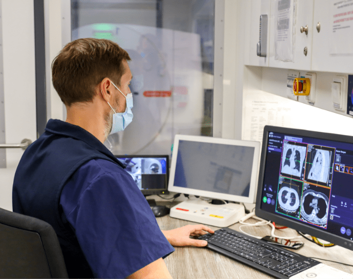 healthcare professional looking a scan images on a computer